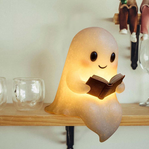 Ghost reading book night light on an indoor shelf